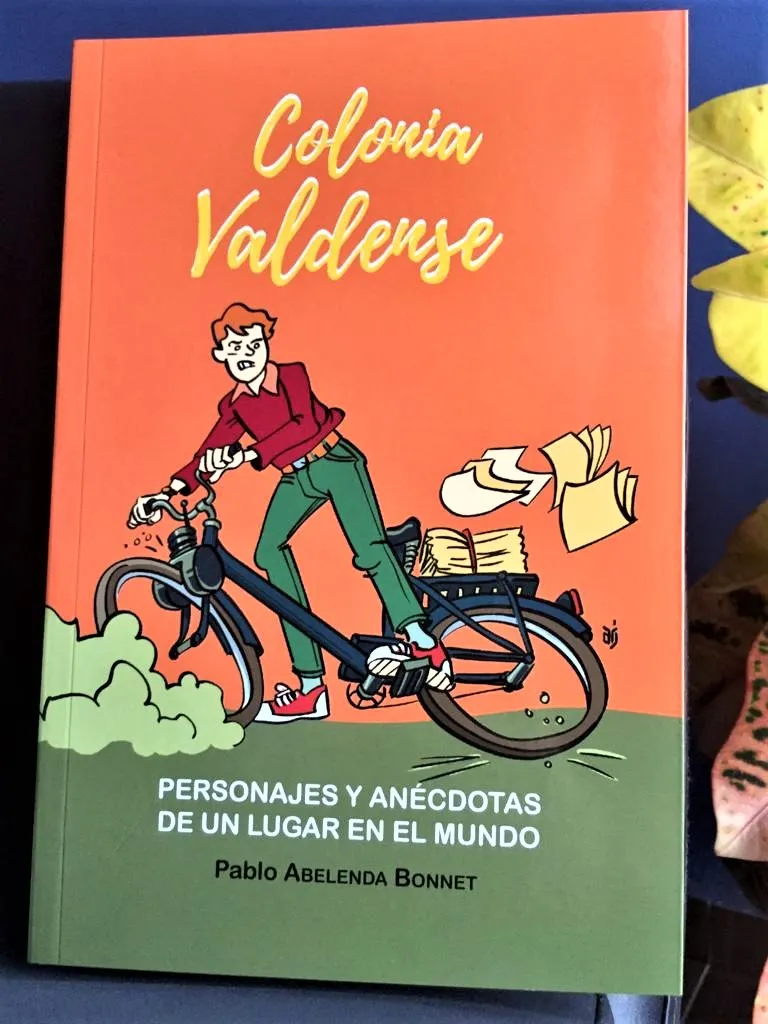 Tapa naranja y verde del libro Colonia Valdense, con un joven en bicicleta
